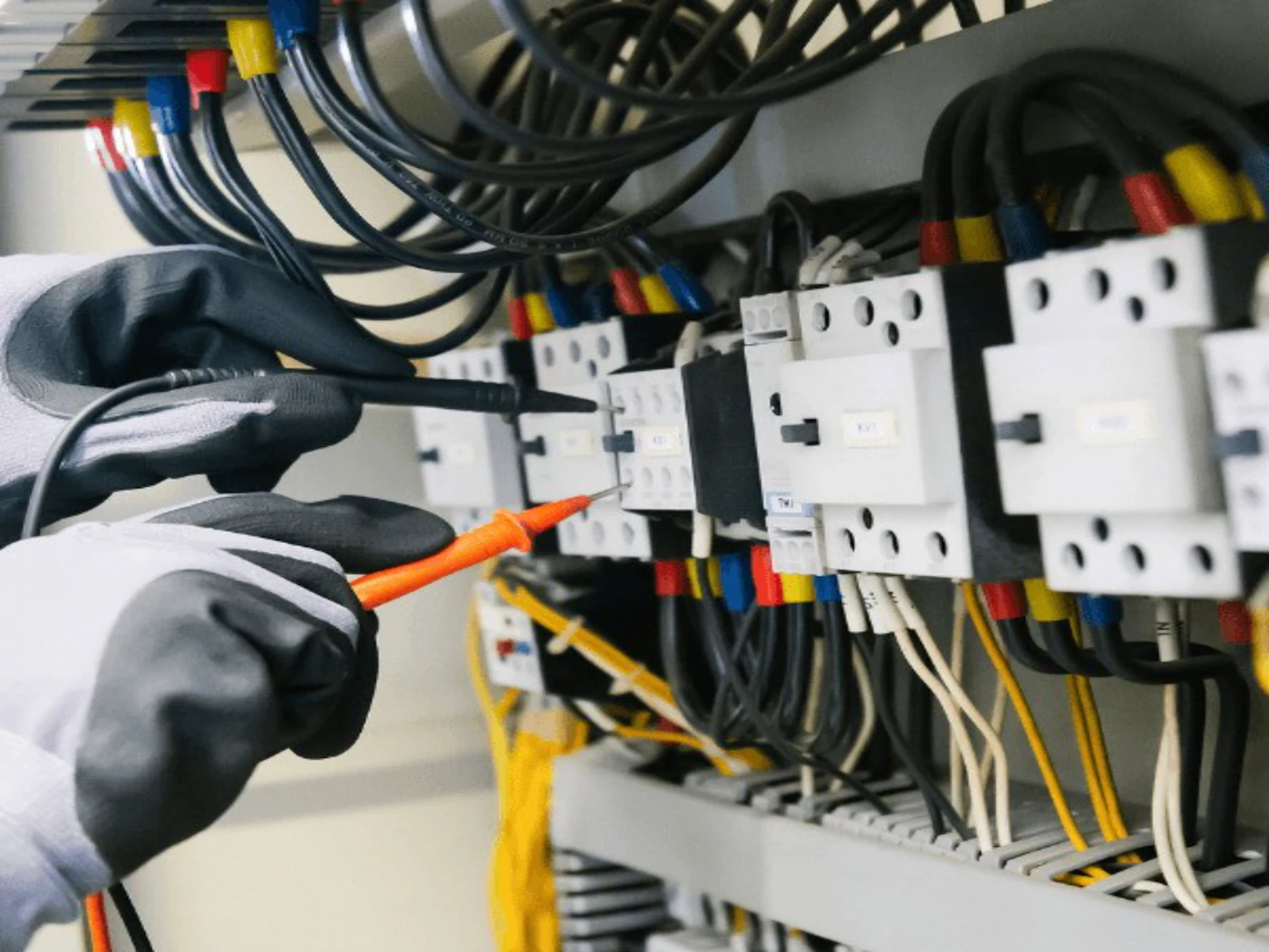 Elektriker prüft die Verdrahtung in einem Schaltschrank